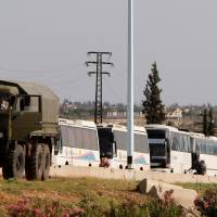 Buses carrying rebels who were evacuated from Rastan are seen in Homs countryside, Syria, Monday. | REUTERS