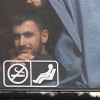A rebel looks out of a bus as he is evacuated with others from Rastan, in Homs countryside, Syria, Monday. | REUTERS