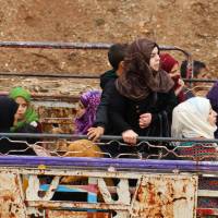 Syrians gather at a departure point prior to being evacuated from the rebel-held town of Rastan, in Syria\'s central Homs province, in a convoy of buses on Monday after rebels and civilians were granted safe passage to the rebel-held town of Jarabulus, in Aleppo province, following a new deal between rebel fighters and the government. | AFP-JIJI