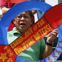 A protester shouts slogans during a rally at the Chinese Consulate to protest China\'s deployment of missiles on Philippine-claimed reefs in the South China Sea, on Friday in the financial district of Makati city, east of Manila. | AP