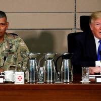 U.S. President Donald Trump delivers remarks before receiving a briefing from military commanders at Camp Humphreys in Pyeongtaek, South Korea, on Nov. 7. Beside him is Gen. Vincent Brooks. | REUTERS