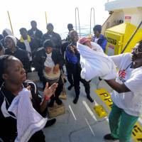 Migrants dance and sing to celebrate the birth of Miracle, a baby who was born on board the Aquarius, in the central Mediterranean Sea, Saturday. | REUTERS