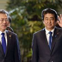 Prime Minister Shinzo Abe and South Korean President Moon Jae-in walk together at the Prime Minister\'s Office before their meeting on Wednesday. | AP