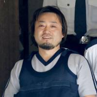 Motomu Oda leaves a police station in Chiba on Tuesday to be sent to prosecutors in connection with the stabbing of four family members. | KYODO