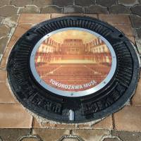 A manhole cover design created by the Tokorozawa Municipal Government is displayed as an example as the city prepares to use the lids as an advertising medium. | TOKOROZAWA CULTURAL FOUNDATION
