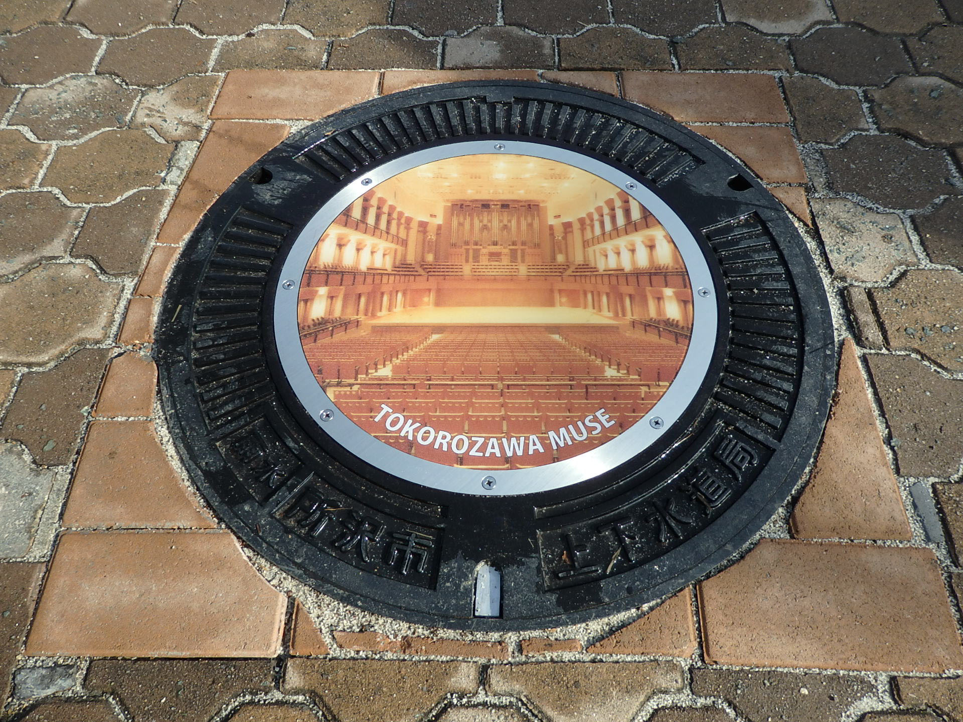A manhole cover design created by the Tokorozawa Municipal Government is displayed as an example as the city prepares to use the lids as an advertising medium. | TOKOROZAWA CULTURAL FOUNDATION