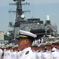 Junior officers of the Maritime Self-Defense Force prepare to undertake navigation training aboard the destroyer Makinami at the MSDF\'s naval base in Yokosuka, Kanagawa Prefecture, on Monday. | DAISUKE KIKUCHI