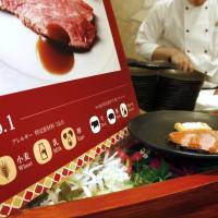 A sign explaining the use of dietary pictograms is placed beside a dish at a restaurant in Osaka in April. | KYODO