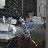 A crack is visible in a glass window at a clinic in Mashiki, Kumamoto Prefecture. Police believe parts fell from a Japan Airlines plane and hit the window on Thursday. | KYODO