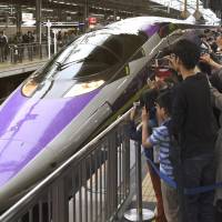 Fans snap photos of a lavender,  anime-themed shinkansen based on “Shinseiki Evangelion” (“Neon Genesis Evangelion”) on Sunday, the last day of its extended run, at JR Shin-Osaka Station. The bullet train, which debuted in 2015 between Shin-Osaka and Hakata stations, was supposed to be taken out of service in March 2017 but was extended by popular demand.  | KYODO