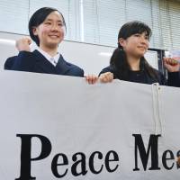 Two high school students pose for a photo on April 4 in Nagasaki after being chosen as student peace ambassadors. A group of 20 student peace ambassadors from Japan plan to visit Geneva for the Conference on Disarmament in August, but they are unlikely to be allowed to address the meeting. | KYODO.