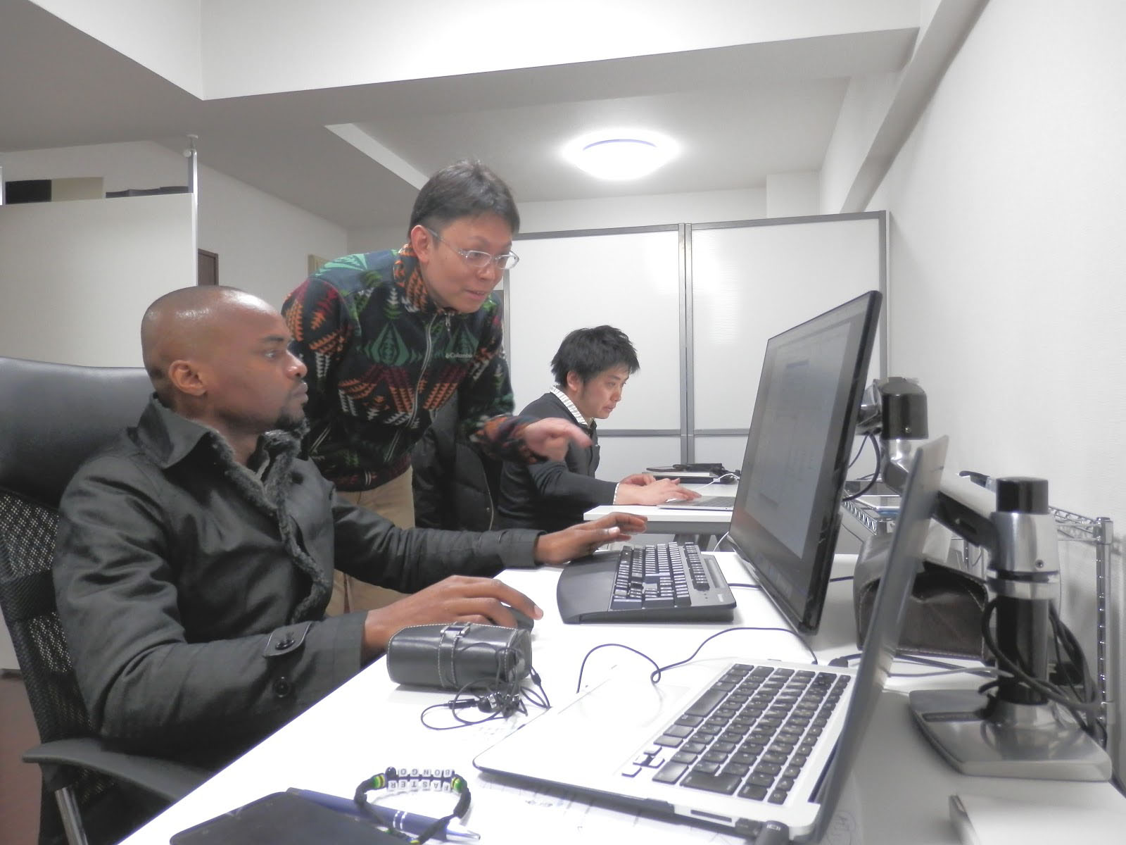 Takahiro Kambe, executive director of Studio Canbe, teaches programming to James Mmari at his office in Osaka Prefecture. | COURTESY OF TAKAHIRO KAMBE