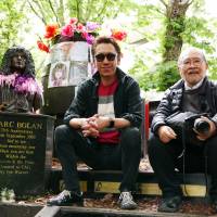 Japanese representation: Musician Tomoyasu Hotei (left) sits with photographer Masayoshi Sukita at the grave of British glam rocker Marc Bolan. | © 2018 \"SUKITA\" PARTNERS
