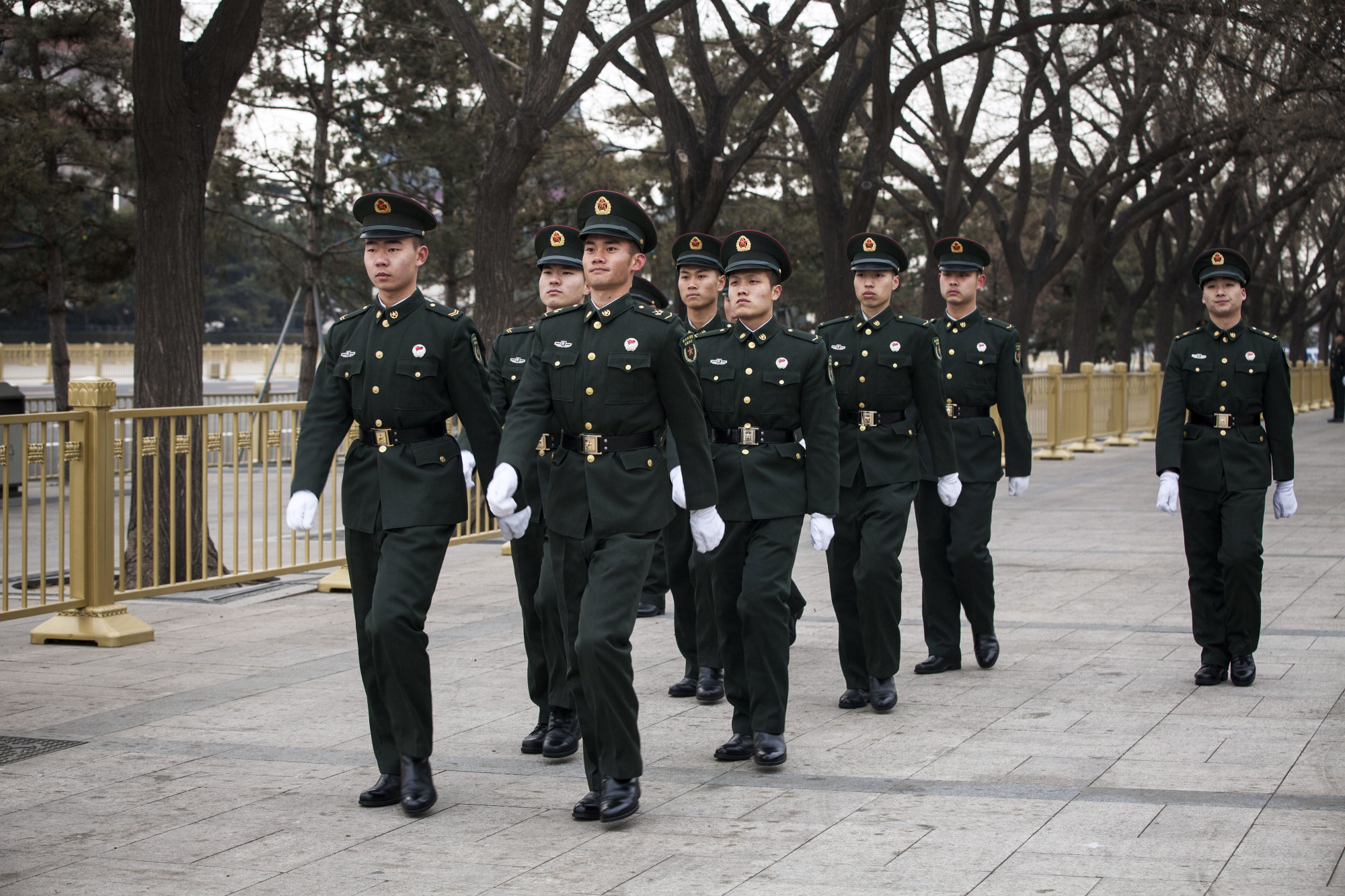 Members of the People's Liberation Army march in Tiananmen Square in Beijing on March 7 as President Xi Jinping prepared to enact a sweeping government overhaul that gave the Communist Party greater control over everything from financial services to entertainment. | BLOOMBERG