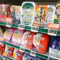 Easy eats: Different brands of microwavable rice line the shelves of a Tokyo grocery store. | KYODO