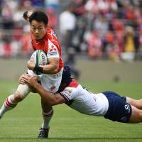 The Sunwolves\' Kenki Fukuoka is tackled by Reds\' fullback Hamish Stewart in Super Rugby action in Tokyo on Saturday. | AFP-JIJI