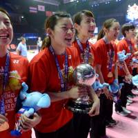 Japan team captain Ayaka Takahashi holds the trophy as she and her teammates celebrate winning the Uber Cup on Saturday in Bangkok. | AFP-JIJI
