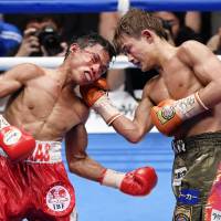 Hiroto Kyoguchi (right) lands a punch on Vince Paras of the Philippines during their IBF minimumweight title fight on Sunday. | KYODO