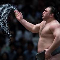 Tochinoshin throws salt before his bout on the 11th day of the Summer Grand Sumo Tournament at Ryogoku Kokugikan. | JOHN GUNNING