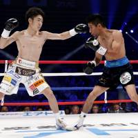 WBC light flyweight champion Ken Shiro (left) punches Mexican challenger  Ganigan Lopez in the first round of their title fight on Friday at Ota City General Gymnasium. | AP