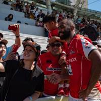 Fans at Hong Kong\'s Mong Kok Stadium take photos with the Sunwolves\' Michael Leitch after the team\'s May 19 Super Rugby game against the Stormers. | AFP-JIJI