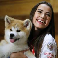 Olympic figure skating champion Aliva Zagitova holds an Akita puppy named Masaru in Moscow on Saturday. | AP