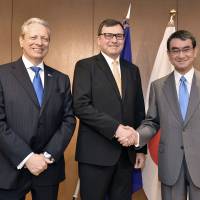 Petr Jezek, chair of the European Parliament Delegation for Relations with Japan (center), shakes hands with Foreign Minister Taro Kono (right) and European Union Ambassador Viorel Isticioaia-Budura during a reception to celebrate Europe Day in Tokyo on May 10. | YOSHIAKI MIURA