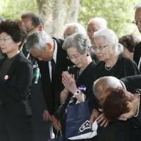People pray for unidentified Japanese war dead from World War II on Monday at Chidorigafuchi National Cemetery in Chiyoda Ward, Tokyo, after some remains were recently repatriated from overseas. | KYODO