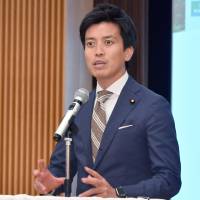 Fumiaki Kobayashi, concurrently serving as the parliamentary vice-minister for Internal Affairs and Communications, and the Cabinet Office, speaks at the beginning of the symposium in Tokyo on May 16. YOSHIAKI MIURA | SATOUMI ZUKURI KENKYU KAIGI