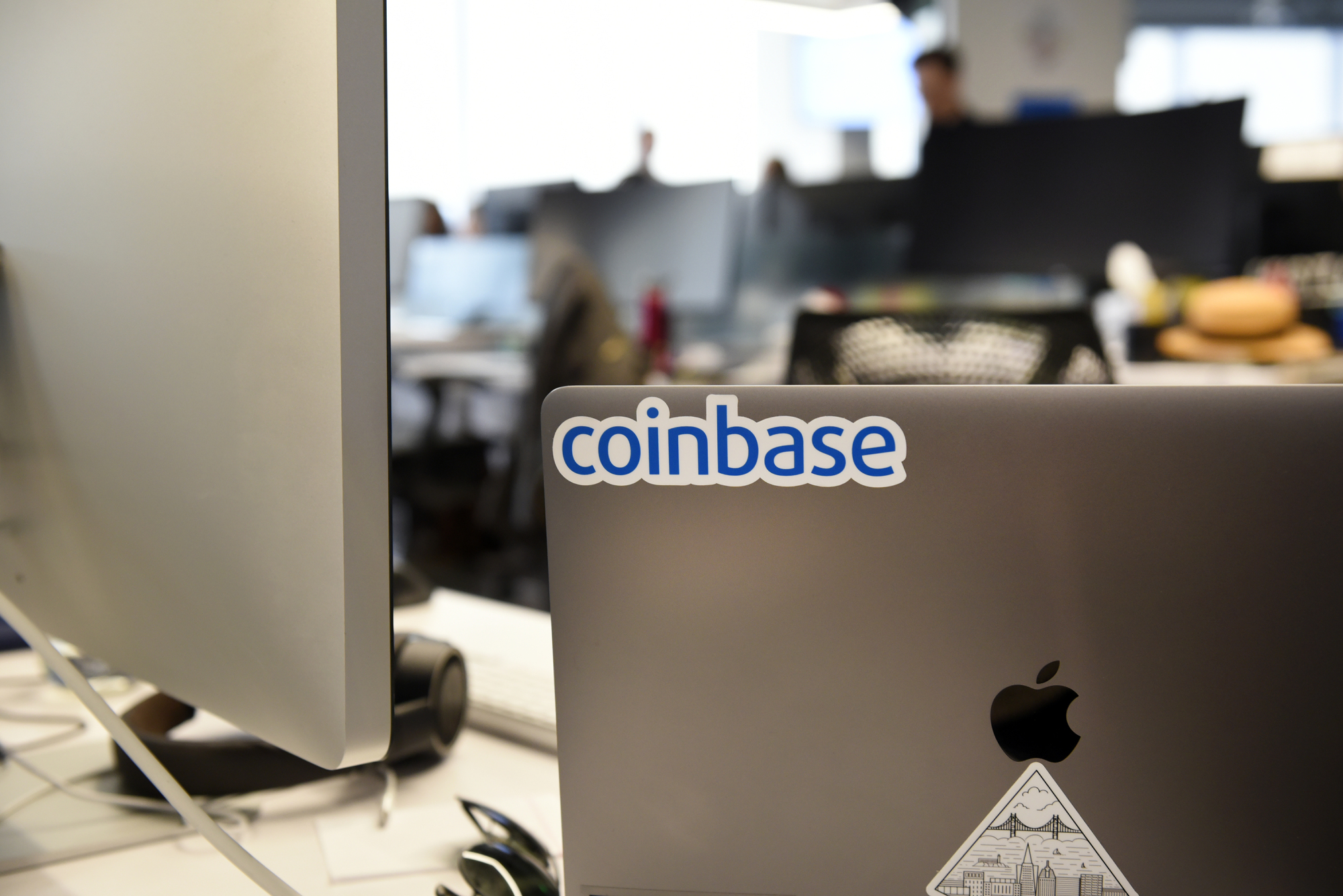 A Coinbase Inc. sticker is seen on a laptop computer at the company's office in San Francisco last Dec. 1. | BLOOMBERG
