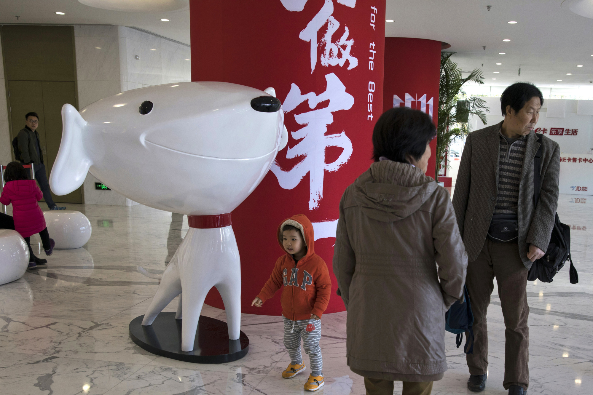 A child stands near the mascot for Chinese e-commerce giant JD.com and the words for 'Be Number One' at the headquarters in Beijing last November. Google said Monday it will invest &#36;550 million in Alibaba's main rival, JD.com, as the U.S. tech giant seeks to expand in fast-growing Asian e-commerce markets. | AP
