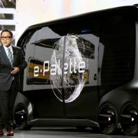 Toyota Motor Corp. President Akio Toyoda shows a fully autonomous vehicle prototype in Las Vegas in January. | KYODO