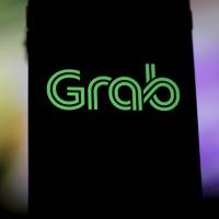Grab\'s logo is seen on a smartphone screen. Toyota Motor Corp. will acquire a &#36;1 billion stake in the ride-hailing firm in one of the largest investments by a carmaker in the industry. | BLOOMBERG