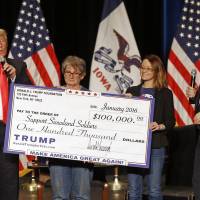 Donald Trump (left) stages a check presentation with an enlarged copy of a &#36;100,000 contribution from the Donald J. Trump Foundation to Support Siouxland Soldiers during a campaign event in Sioux City, Iowa, in 2016 during Trump\'s run for president. New York Attorney General Barbara Underwood filed a lawsuit Thursday accusing Trump of illegally using his charitable foundation to pay legal settlements related to his golf clubs and to bolster his presidential campaign with Foundation disbursements such as this one in Iowa. Also pictured is Jerry Falwell, Jr. (right). | AP