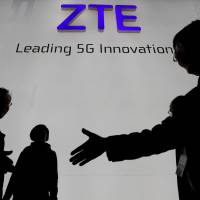 Visitors pass in front of the Chinese telecoms equipment group ZTE Corp. booth at the Mobile World Congress in Barcelona, Spain, in February. | REUTERS