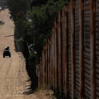 Border patrol agents use all-terrain vehicles while searching for illegal immigrants along the wall on the U.S. border with Mexico in Tecate, California, on Monday. | REUTERS