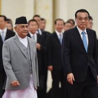 Nepal\'s Prime Minister K.P. Sharma Oli (front left) walks with Chinese Premier Li Keqiang during a welcome ceremony at the Great Hall of the People in Beijing on Thursday. | AFP-JIJI