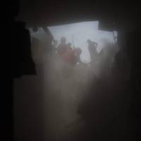 Residents search for victims of the Fuego volcano in the ash-covered village of San Miguel Los Lotes, in Escuintla department, about 35 km southwest of Guatemala City, on Thursday. The threat of fresh landslides forced emergency workers Thursday to suspend a search for victims of a major eruption of Guatemala\'s Fuego volcano, the country\'s disaster management agency said. | AFP-JIJI
