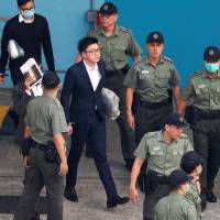 Pro-independence activist Edward Leung walks inside a detention center before leaving for the High Court for a sentencing hearing in Hong Kong on Monday. | REUTERS