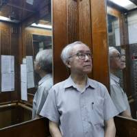 Hong Kong landlord Ng Goon-lau rides the elevator in a building where two suicides have taken place. | REUTERS