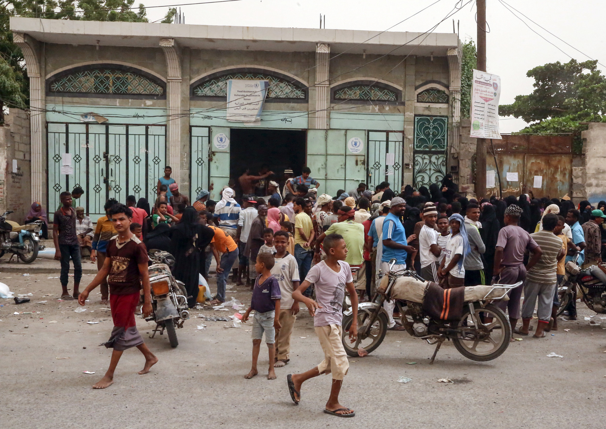 Yemeni civilians receive food aid in the coastal city of Hodeidah on Thursday. | AFP-JIJI