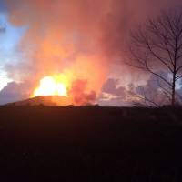 Crews watch activity at fissure 8 of Kilauea volcano on Thursday morning, when fountain heights continued to reach 70 to 80 meters (230 to 260 feet), feeding a lava flow that was moving to the northeast along Highway 132 into the area of Noni Farms Road | U.S. GEOLOGICAL SURVEY / VIA AFP-JIJI