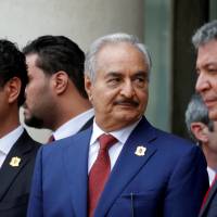 Khalifa Hifter (center), the military commander who dominates eastern Libya, leaves after an international conference on Libya in Paris May 29. | REUTERS