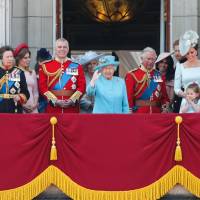 Royal family members (from left) Meghan, Duchess of Sussex; Prince Charles; Catherine, Duchess of Cambridge (with Princess Charlotte and Prince George); and Prince William, Duke of Cambridge, stand on the balcony of Buckingham Palace to watch a fly-past of aircraft by the Royal Air Force in London on Saturday during the Trooping the Colour ceremony to mark the official birthday of the queen, whose actual birthday is on April 21. | AFP-JIJI