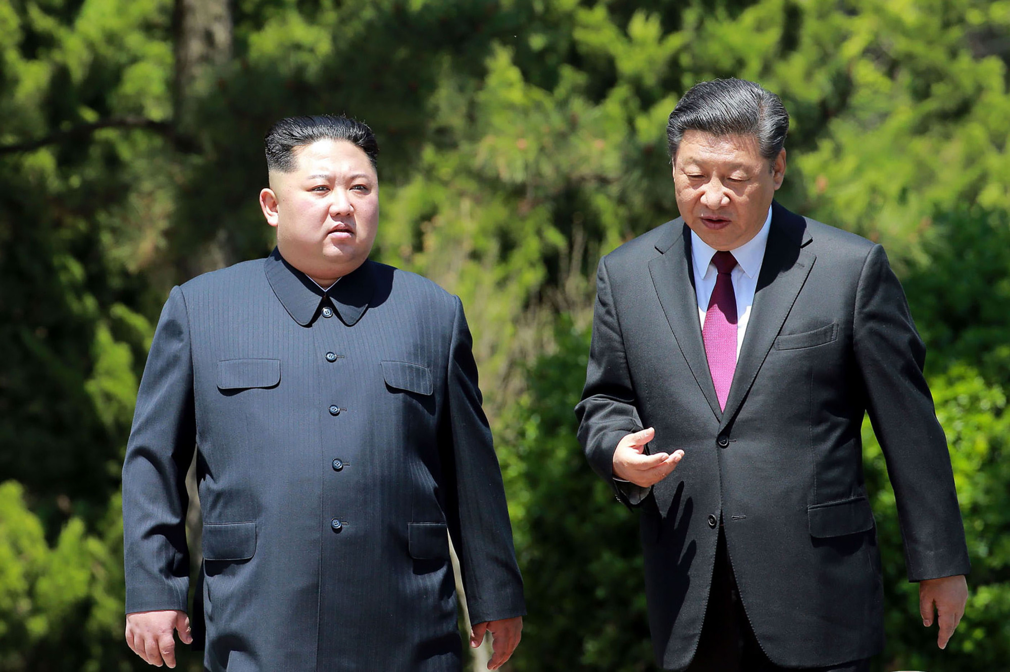 Chinese President Xi Jinping walks with North Korean leader Kim Jong Un in Dalian, China, on May 8. | KCNA / KNS / AFP-JIJI
