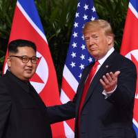 US President Donald Trump gestures as he meets with North Korea\'s leader Kim Jong Un at the start of their historic U.S.-North Korea summit, at the Capella Hotel on Sentosa island in Singapore on Tuesday. | AFP-JIJI