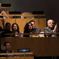 Palestinian Ambassador to the United Nations Riyad Mansour applauds the results of the vote to condemn Israeli actions in Gaza, in the General Assembly Wednesday in New York. The U.N. General Assembly adopted by a strong majority of 120 countries an Arab-backed resolution condemning Israel for Palestinian deaths in Gaza and rejected a U.S. bid to put the blame on Hamas. | AFP-JIJI