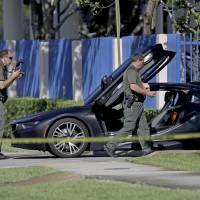 Investigators surround a vehicle after rapper XXXTentacion was shot dead on Monday in Deerfield Beach, Florida. The Broward Sheriff\'s Office says the 20-year-old rising star was pronounced dead Monday evening at a Fort Lauderdale-area hospital. | JOHN MCCALL / SOUTH FLORIDA SUN-SENTINEL / VIA AP