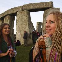 Revellers celebrate the summer solstice at Stonehenge in Wiltshire, England, on June 21, 2018. Modern druids and others gather at the ancient landmark every year to see the sun rise. | AFP-JIJI