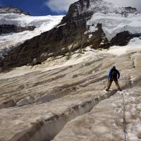 Mountain guide Christian Pletscher walks toward the Aletsch glacier from the Jungfraufirn glacier in Switzerland in August 2015. One of Europe\'s biggest glaciers, the Great Aletsch Glacier coils 23 km through the Swiss Alps, but has retreated about 3 km since 1870 &#8212; and that pace is quickening. | REUTERS
